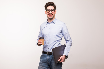 Business man in glasses and, in suit, holding laptop and cup of coffee isolated on white background