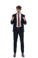 Confident businessman pointing forward with both hands