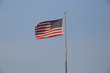 american flag against blue sky with copy space for text