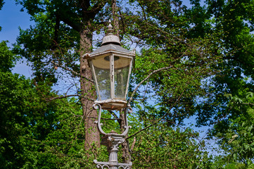Historic street lamp that was powered by gas and stands in a Berlin park.