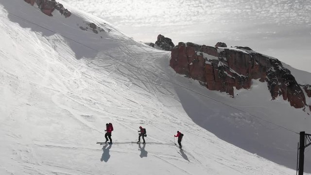 Three Skiers Walking in Powder Snow