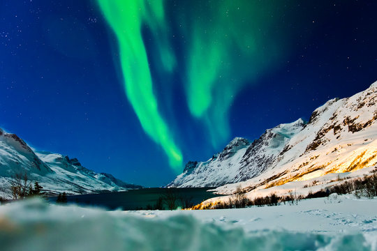 Zorza polarna nad Ersfjordbotn w Norwegii. Zimowe wyjazdy nad arktyczne fiordy.