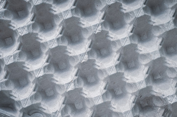 Tray with raw eggs , gray colored background. Cells made of eco-friendly material, pressed paper.