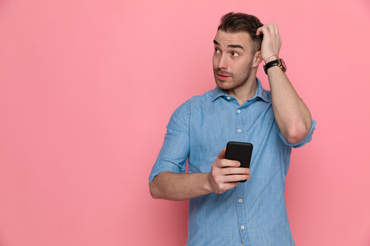 casual man scratching his head, looking aside