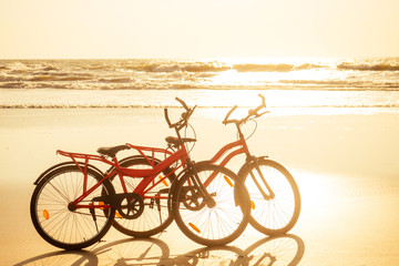 Fototapeta premium two bicycles and empty beach without people.no body at sunset