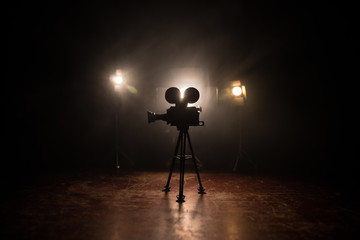 Movie concept. Miniature movie set on dark toned background with fog and empty space. Silhouette of...