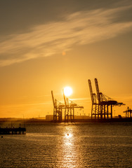 Large ship to shore container cranes at sunset..