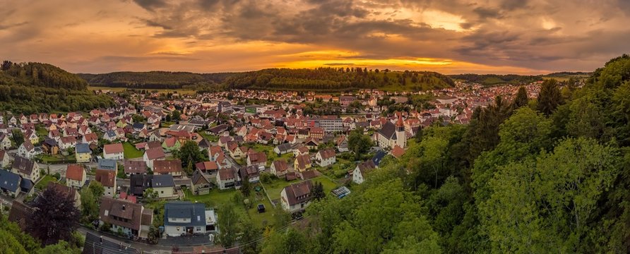 Germany, Albstadt at the Schwaebische Alb skyline of medieval city illuminated by the dawn, aerial view above roofs and houses at sunset