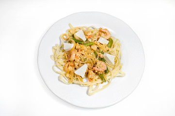 Noodles with seafood and cheese on a white plate on a white background