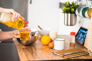 Woman making a cake recipe via online in her kitchen