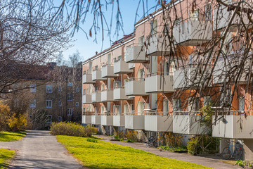 Fototapeta na wymiar Facade of an orange apartment building with white balconies.