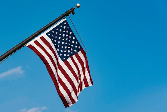 USA flag, American flag on flagpole against blue sky with space for text, high resolution picture