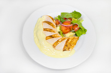 Sliced grilled pork with mashed potatoes and salad on a white plate on a white plate