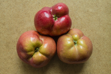 Three curves of ripe red apples close-up isolated and copy space. Trend-ugliness
