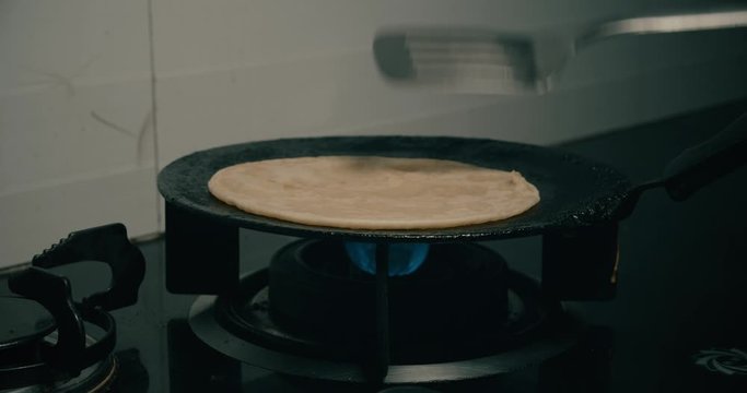 Person making paratha and brushing oil on it