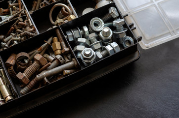 Open plastic box with various bolts.