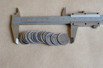 The caliper measures Ukrainian coins of a face value of 5 kopecks.