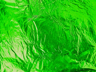 Green shiny wrinkled aluminum foil as background