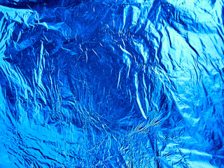 Blue shiny wrinkled aluminum foil as background