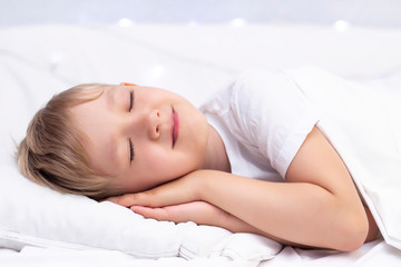 Obraz na płótnie Canvas Charming little white boy sleeps in bed.