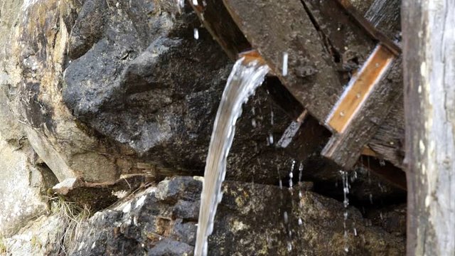 Slow motion of Takayama, Japan traditional wooden house building mill wheel with water running in Hida no Sato old folk village closeup