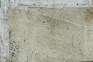 Fragment of texture of concrete building wall with old cracked dirty surface. Abstract grunge background close up for your design