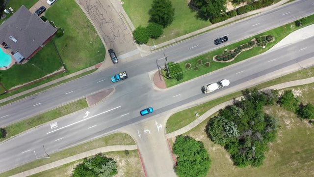 Descending flight over a residential 4 lane divided street intersection, with light traffic, Bryan, Texas