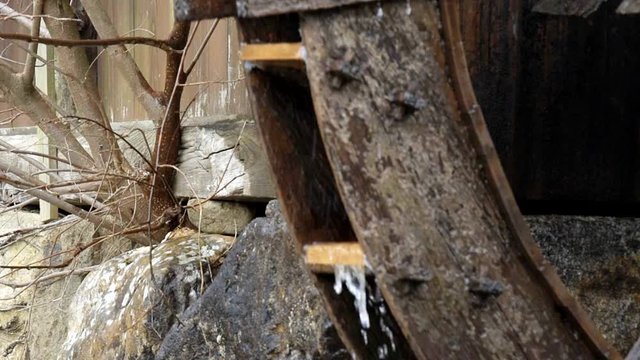 Slow motion of Takayama, Japan traditional historical wooden house building mill wheel with water running in Hida no Sato old folk village closeup