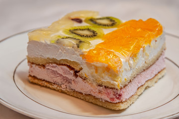 home-cooked biscuit cake with a layers of home-made cottage cheese decorated with tropical fruits