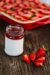 Strawberry cake and yogurt with strawberry jam on the dark wooden background