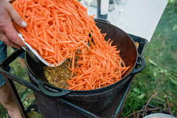 Pilaf Cooking in cauldron on fire outdoors series.