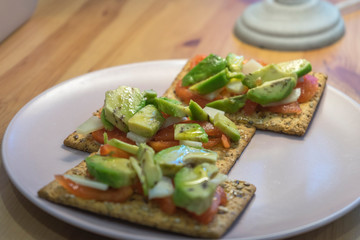healthy toast with tomato avocado and cheese on wooden table
