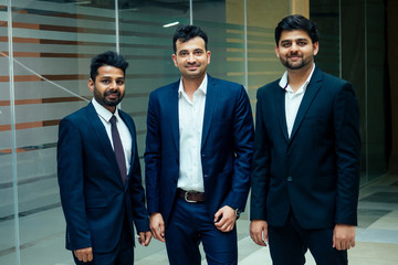 well-dressed business indian men making a report to subordinate employees in a modern office