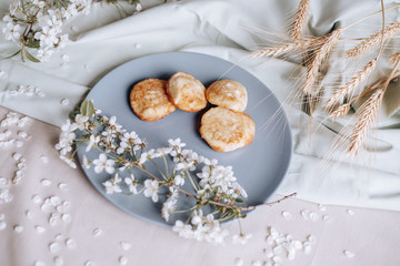 spring healthy Breakfast fried cheesecakes, against a blooming bouquet flowers