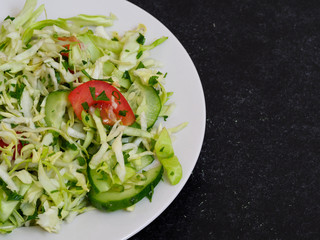 Cabbage salad and tomato on a plate. Dietary salad with fresh vegetables