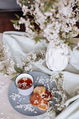 Breakfast in the morning, toasted beautiful cheesecakes on a plate on the tablecloth next to a spring bouquet of flowers