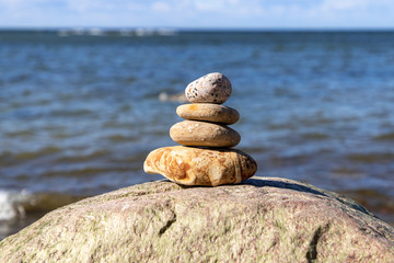 Concept of harmony and balance. Rock zen on a background of a summer beach.