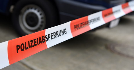 Rot-weißes Band mit der Aufschrift: Polizeiabsperrung