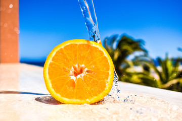 beautiful half orange with water under a blue sky