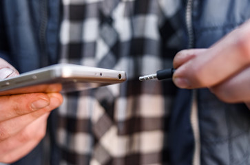 the man inserts the plug into the headphone jack
