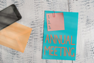 Text sign showing Annual Meeting. Business photo showcasing Yearly gathering of an organization interested shareholders Envelope blank sheet paper sticky note smartphone wooden vintage background