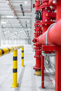 fire suppresion system in a empty industrial hall red pipes and bariers