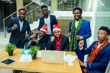 happy group of indian and african american people drinking toast from cup,wearing santa hat and...