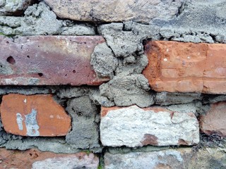 Brick wall. Ceramic masonry or fence. Old, uneven brick, covered in some places with moss and mold....