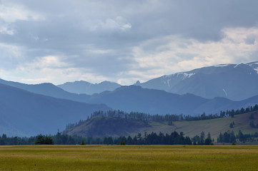 Obraz premium A green plain surrounded by high hills.