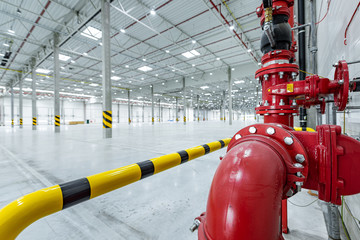fire suppresion system in a empty industrial hall red pipes and bariers