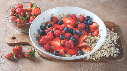Breakfast homemade muesli oatmeal with berries - healthy and diet food concept background on table copy text.