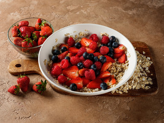 Breakfast homemade muesli oatmeal with berries - healthy and diet food concept background on table copy text.