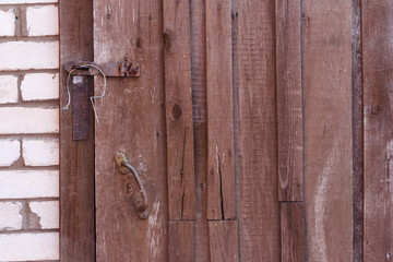 Old wooden door and lock at the entrance to sairay