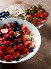 Healthy and diet traditional homemade breakfast - oatmeal flakes with fresh fruits strawberries and blueberries. Healthy lifestyle food homemade recipe.